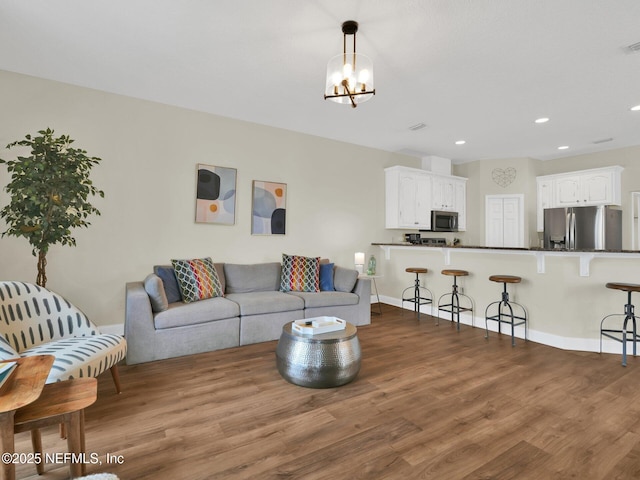 living room featuring an inviting chandelier and dark hardwood / wood-style floors