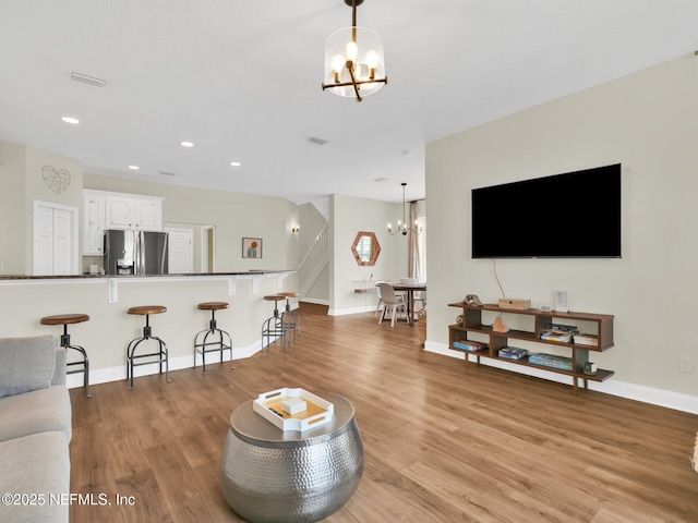 living room featuring an inviting chandelier and light wood-type flooring