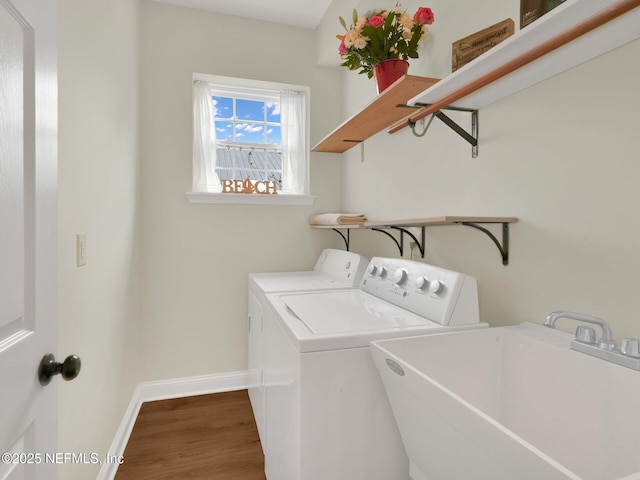 laundry area featuring sink, hardwood / wood-style floors, and independent washer and dryer