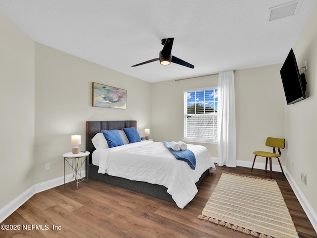 bedroom with dark hardwood / wood-style floors and ceiling fan