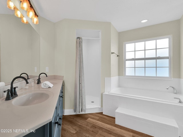 bathroom with vanity, wood-type flooring, and shower with separate bathtub