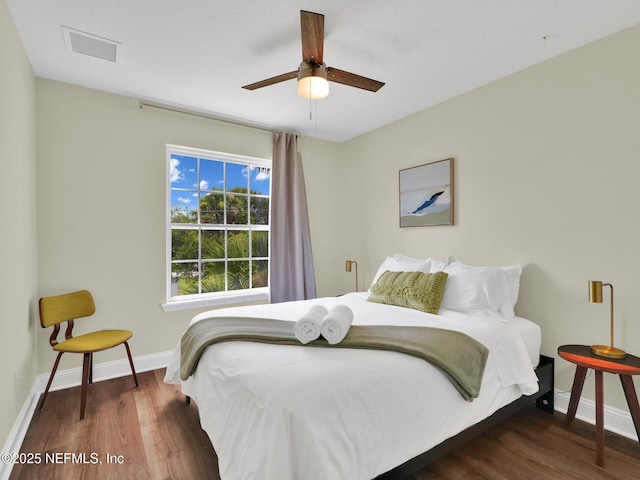 bedroom with dark hardwood / wood-style flooring and ceiling fan