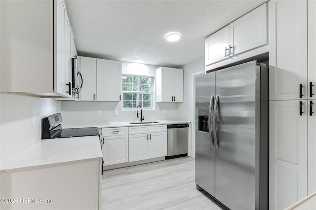 kitchen with white cabinetry, appliances with stainless steel finishes, sink, and a textured ceiling