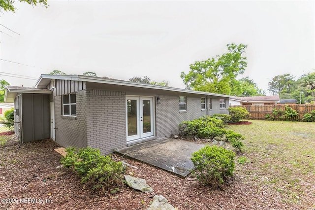 back of property with a patio, a yard, and french doors