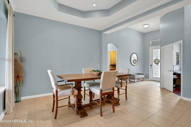 tiled dining space with a tray ceiling