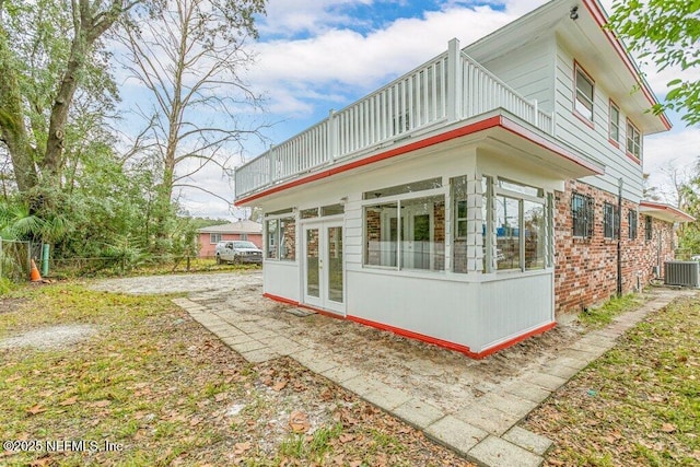 view of side of property featuring french doors and central AC unit