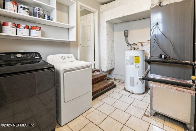 clothes washing area with electric water heater, washer and dryer, and light tile patterned floors