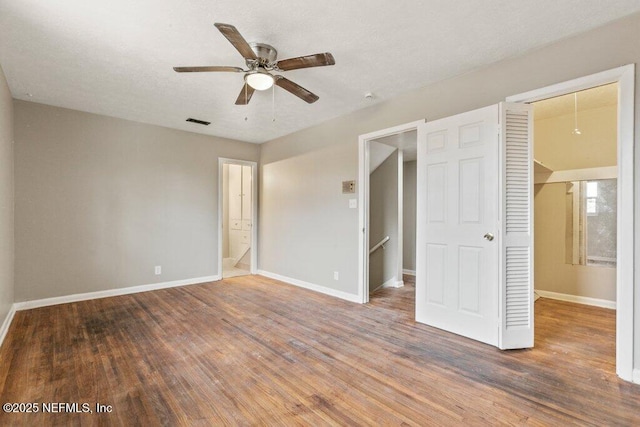 unfurnished bedroom with hardwood / wood-style flooring, ceiling fan, and a closet