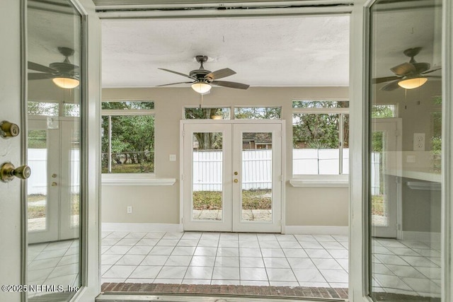 unfurnished sunroom with ceiling fan and french doors