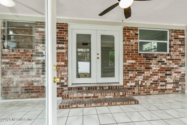 entrance to property with a patio area, ceiling fan, and french doors