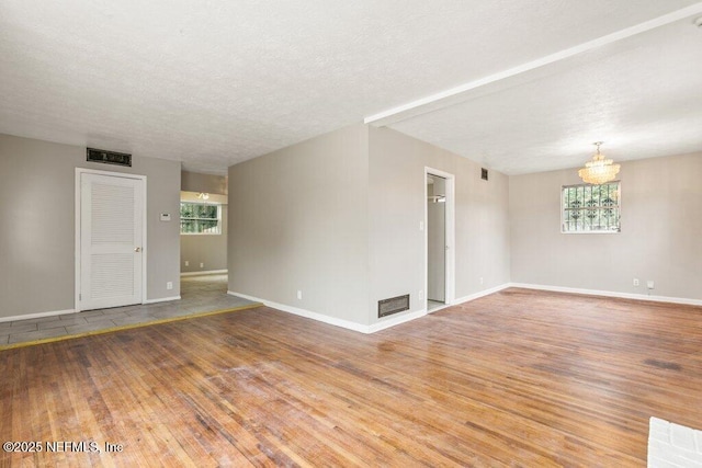 unfurnished room featuring hardwood / wood-style floors and a textured ceiling