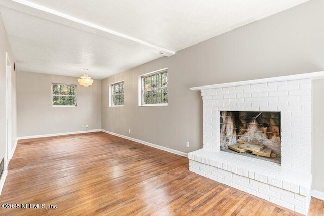 unfurnished living room with hardwood / wood-style flooring, a fireplace, and a wealth of natural light