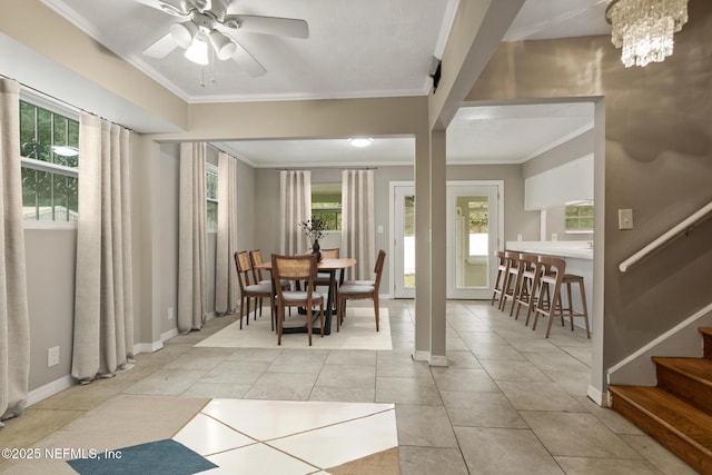 dining area with a wealth of natural light, ceiling fan with notable chandelier, light tile patterned floors, and crown molding