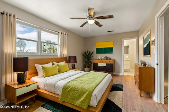 bedroom featuring ensuite bathroom and hardwood / wood-style floors