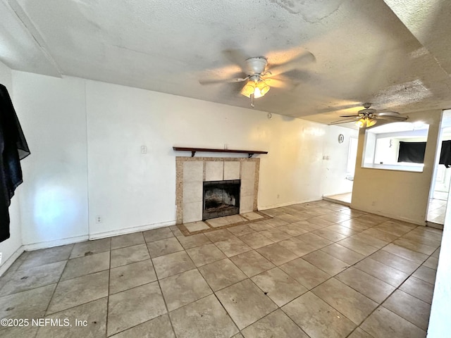 unfurnished living room with a tile fireplace, light tile patterned floors, a textured ceiling, and ceiling fan