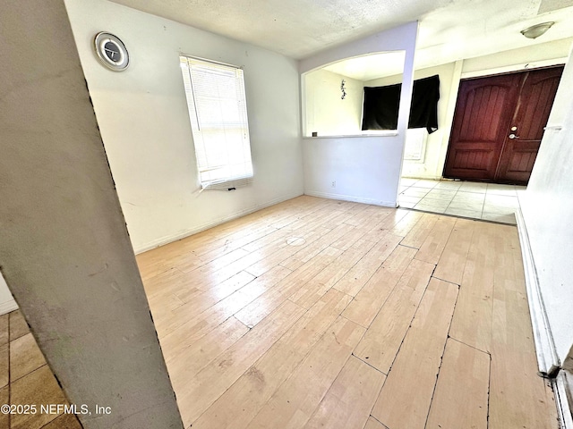 foyer entrance featuring a textured ceiling and light wood-type flooring