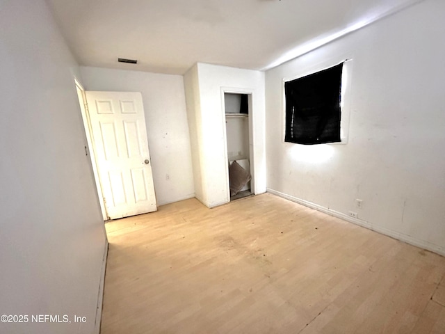 unfurnished bedroom featuring light hardwood / wood-style floors and a closet