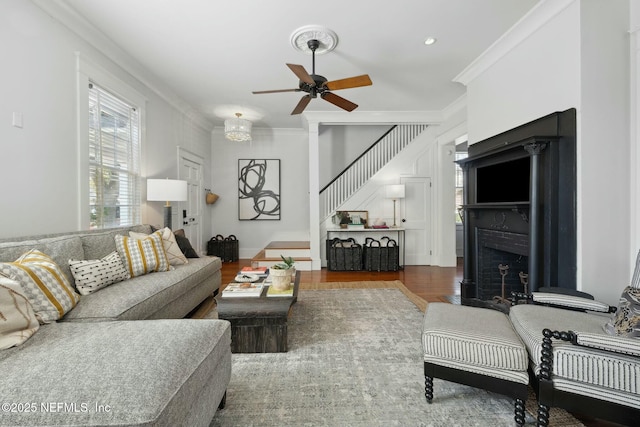 living room featuring crown molding, wood-type flooring, and ceiling fan