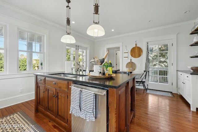 kitchen with sink, crown molding, hanging light fixtures, dishwasher, and an island with sink