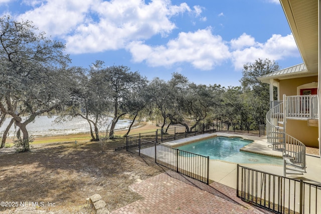 view of swimming pool featuring a water view and a patio area