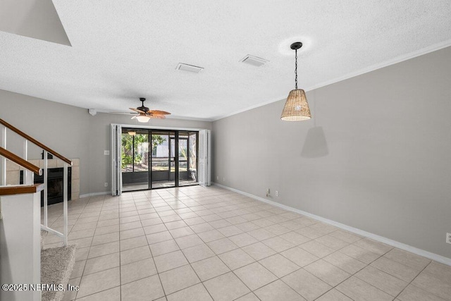 unfurnished living room featuring baseboards, stairs, visible vents, and a textured ceiling