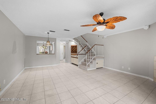 spare room featuring a ceiling fan, crown molding, stairway, and baseboards