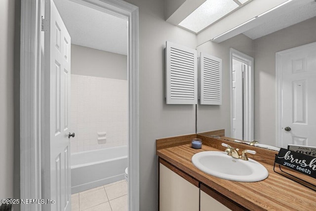 bathroom featuring toilet, a skylight, vanity, and tile patterned floors