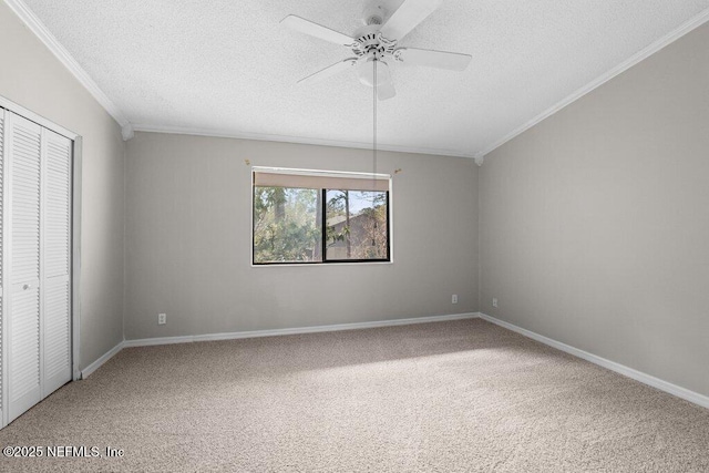 unfurnished bedroom with a textured ceiling, a closet, carpet flooring, and crown molding