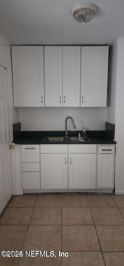 kitchen featuring white cabinetry, tile patterned floors, and sink