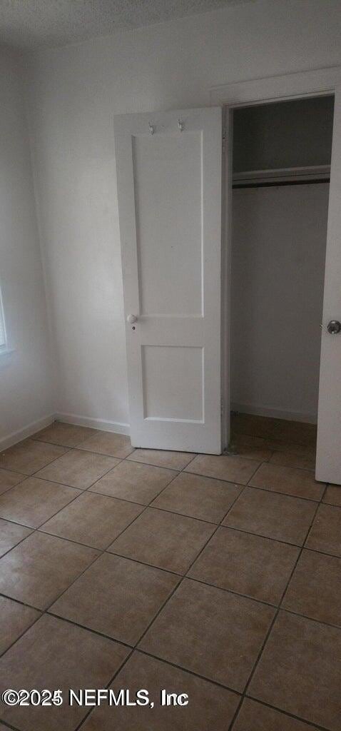 interior space with tile patterned floors and a closet