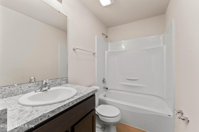 full bathroom featuring vanity, a textured ceiling, shower / washtub combination, and toilet