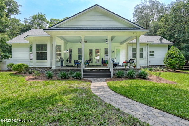 view of front facade with a front yard, ceiling fan, and covered porch