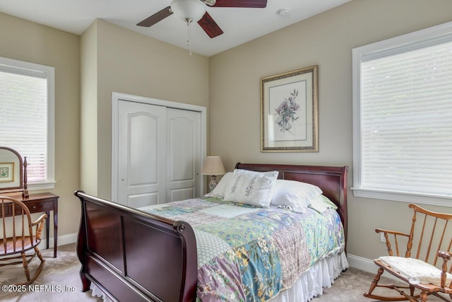 bedroom featuring light colored carpet, a closet, and ceiling fan