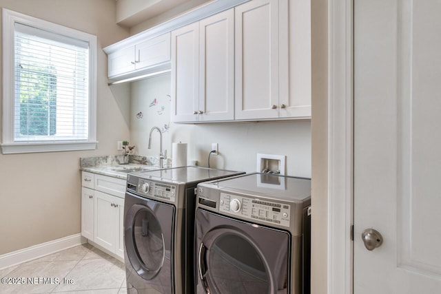 laundry room with cabinets, sink, washer and dryer, and light tile patterned floors