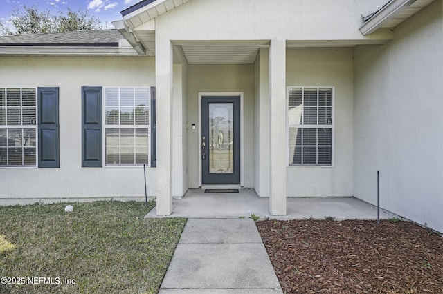 view of exterior entry with a patio area