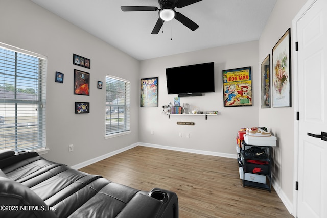 living room with wood-type flooring, plenty of natural light, and ceiling fan