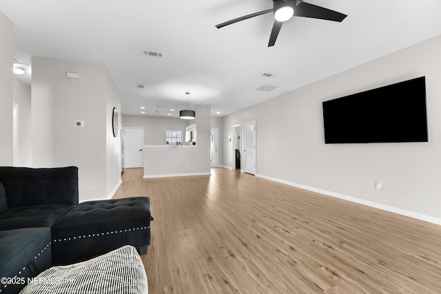 living room with ceiling fan and light hardwood / wood-style flooring