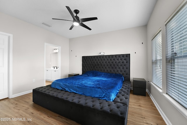 bedroom featuring connected bathroom, wood-type flooring, and ceiling fan