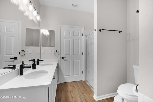 bathroom with vanity, toilet, an enclosed shower, and hardwood / wood-style floors