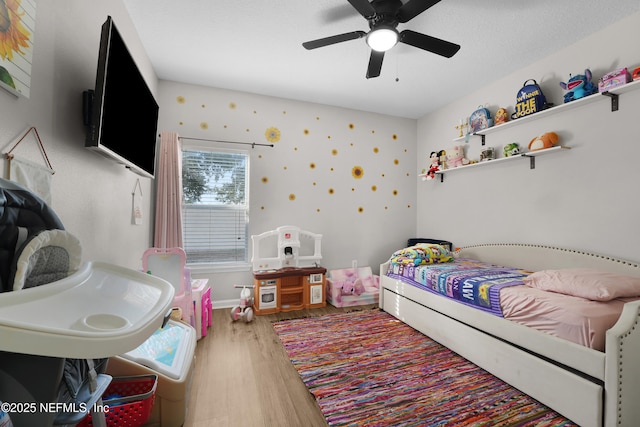 bedroom with hardwood / wood-style flooring, ceiling fan, and a textured ceiling