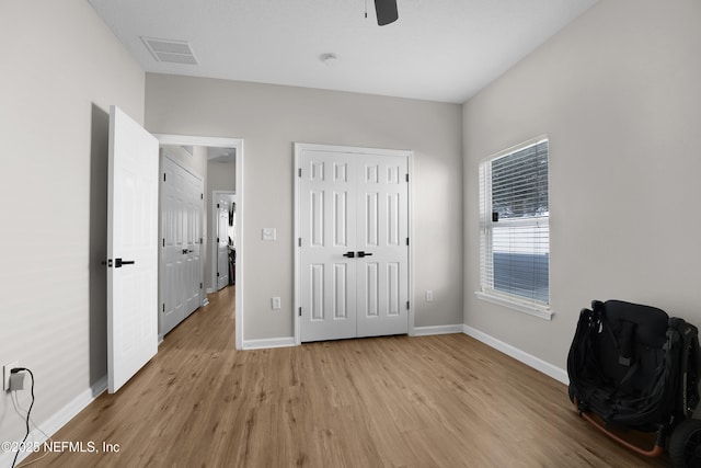 unfurnished bedroom with ceiling fan, light hardwood / wood-style floors, and a closet