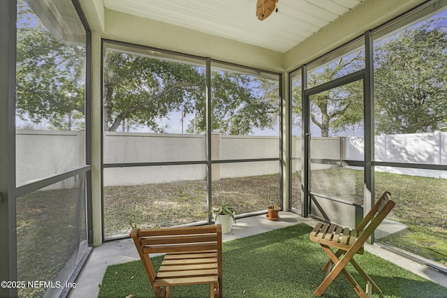 unfurnished sunroom with ceiling fan