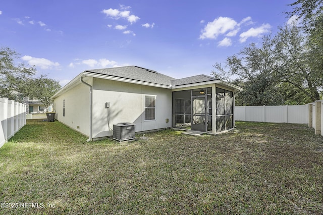 rear view of property featuring a lawn, a sunroom, and central air condition unit