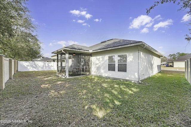 back of house with a yard and a sunroom