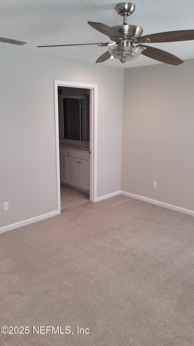 spare room with ceiling fan and light carpet