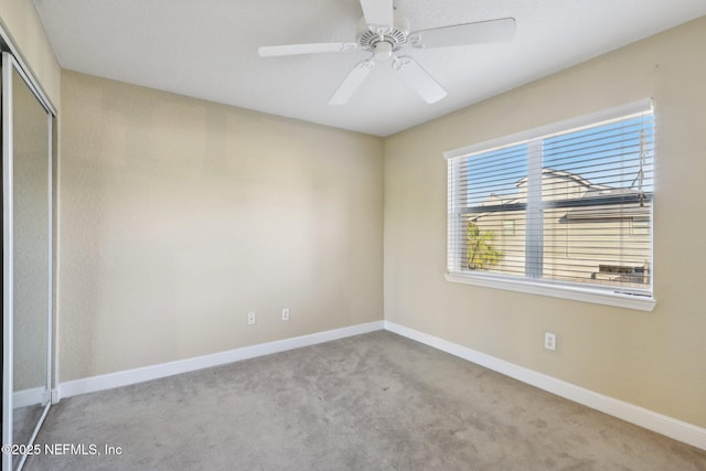 empty room with ceiling fan and light colored carpet