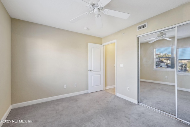 unfurnished bedroom with ceiling fan, light carpet, and a closet