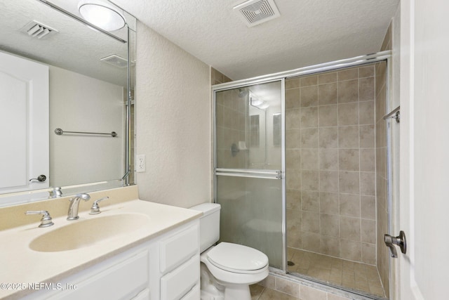 bathroom featuring a textured ceiling, toilet, vanity, and walk in shower