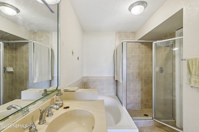 bathroom with sink, independent shower and bath, and a textured ceiling