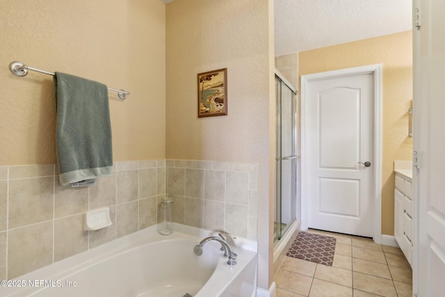 full bathroom featuring a garden tub, tile patterned flooring, vanity, and a shower stall